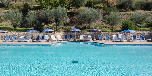 The swimming pool at Villa Grassina, with loungers and the hills behind